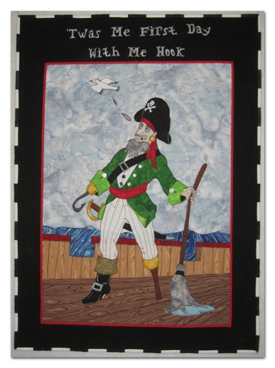 The inspiration drawing was by my husband, Michael Ellis. The materials are commercial cottons. The wording is done with thread painting and the pirate is raw-edge fusible appliqu�.